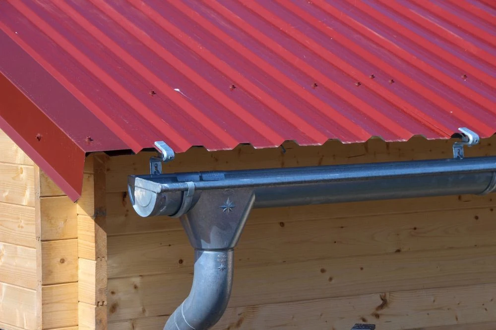 A new metal downpipe fixed down the brick wall of a home